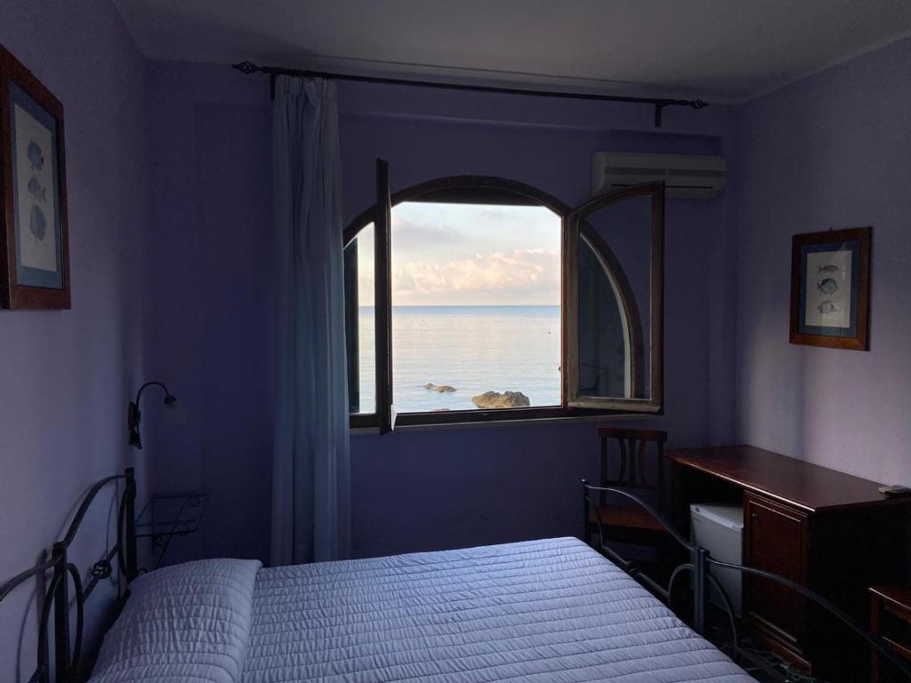 une chambre avec une fenêtre avec vue sur l'océan dans l'établissement Locanda Il Senatore, à Fiascherino