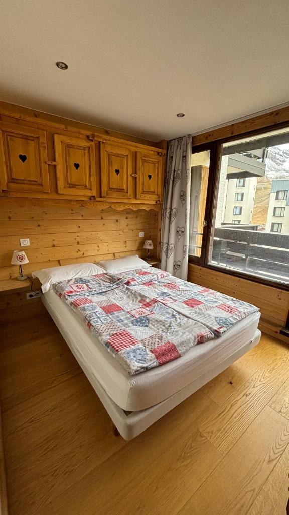 une chambre avec un lit avec une couette dessus dans l'établissement A 5 min du LAC !! 3 pièces 46m2, 6 personnes TIGNES VAL CLARET 2300m, à Tignes