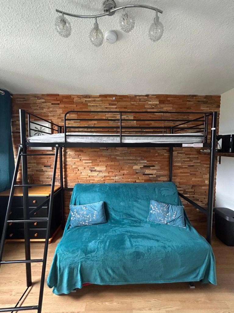 - une chambre avec des lits superposés et une couette verte dans l'établissement Studio cosy avec vue panoramique - Le Corbier, à Villarembert