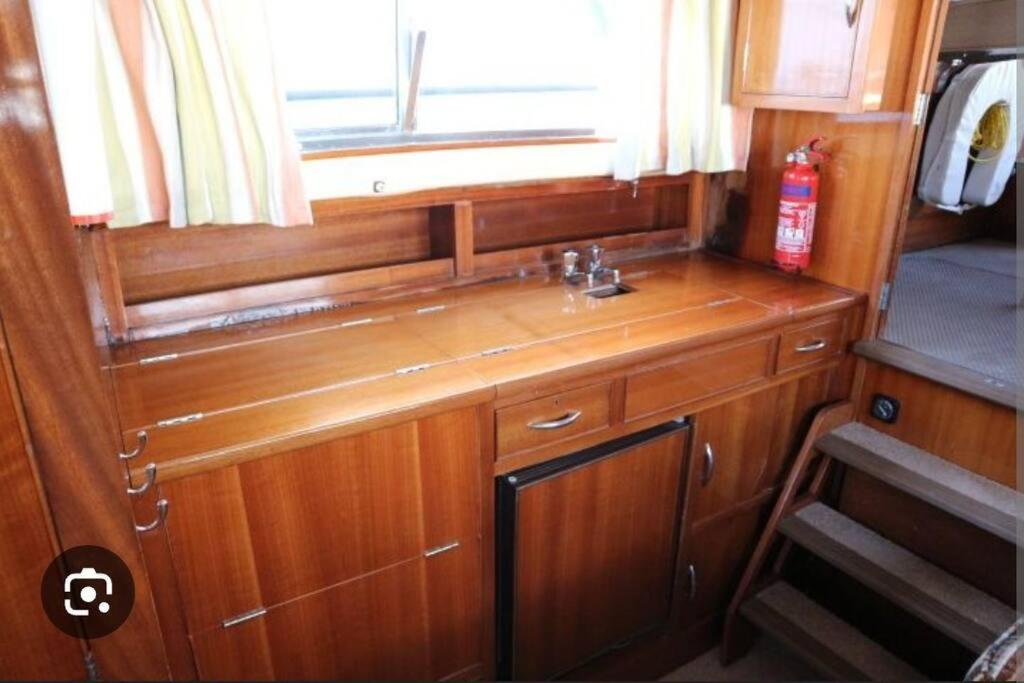 une petite cuisine avec un évier et une fenêtre dans l'établissement Logement atypique sur l'eau aux portes de la Camargue, au Grau-du-Roi