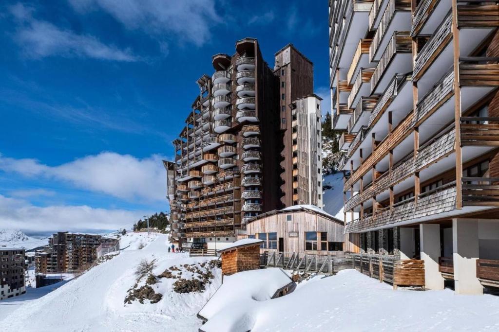 un grand bâtiment dans la neige recouvert de neige dans l'établissement F2 résidence Antarès, à Avoriaz