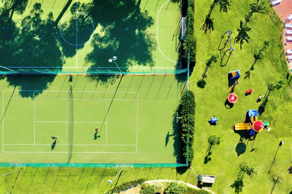 - une vue sur le court de tennis dans l'établissement Village with swimming-pool in Montalto Marina just 100 meters from the beach, mobile homes with air conditioning and private outdoor area, à Torre di Montalto