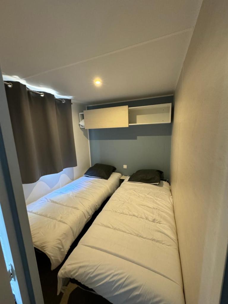 Cette petite chambre comprend 3 lits. dans l'établissement Chez Flo Mobil-Home H13, à Gassin