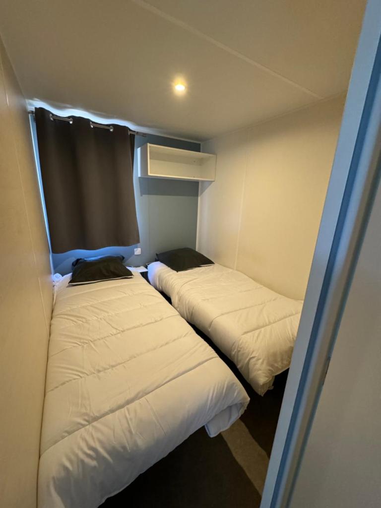 Cette petite chambre comprend 2 lits. dans l'établissement Chez Flo Mobil-Home H13, à Gassin