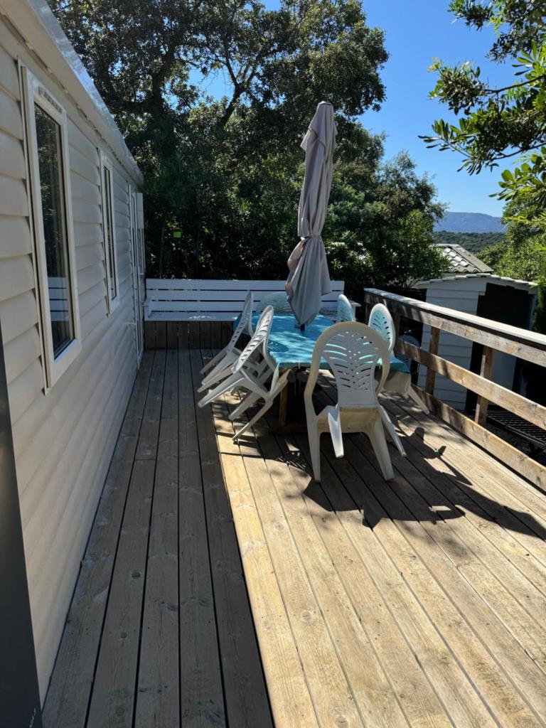 une terrasse avec un parasol et des chaises sur une maison dans l'établissement Chez Flo Mobil-Home H13, à Gassin