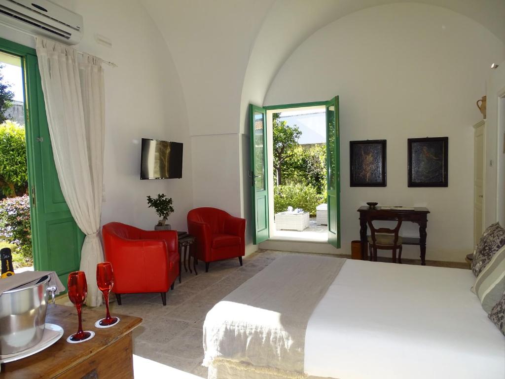 - une chambre avec un lit et deux chaises rouges dans l'établissement Palazzo Ducale Venturi - Luxury Hotel & Wellness, à Minervino di Lecce