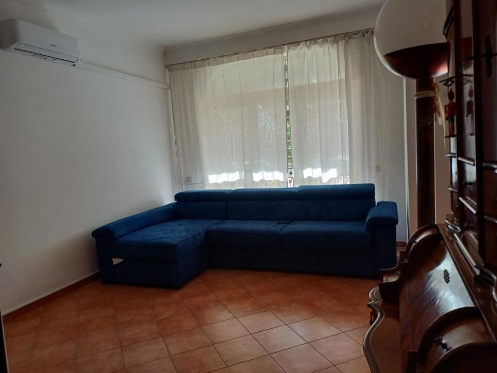 - un canapé bleu dans le salon doté d'une fenêtre dans l'établissement Max House, à Marina di Cerveteri 34 autres photos