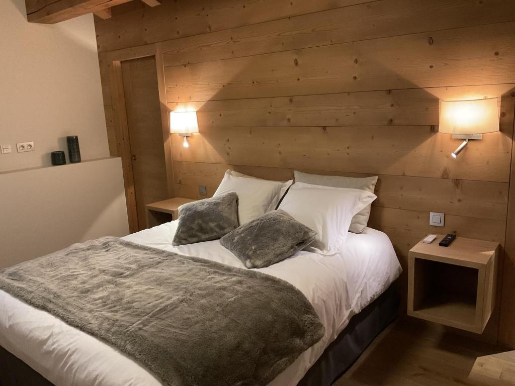 une chambre avec un grand lit avec deux oreillers dans l'établissement Ski in ski out Le Moulin charming duplex just 50 m from Princesse gondola Megève, à Demi-Quartier