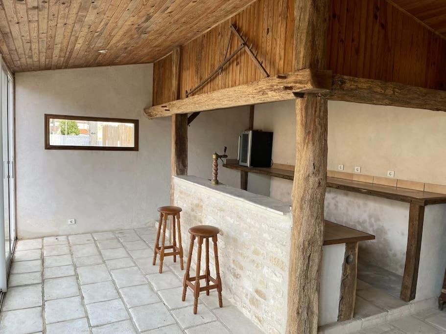 - une cuisine avec deux tabourets et un comptoir dans une pièce dans l'établissement Le Gîte des Jonquilles up to 12 People 6 Bedrooms, à Melleran