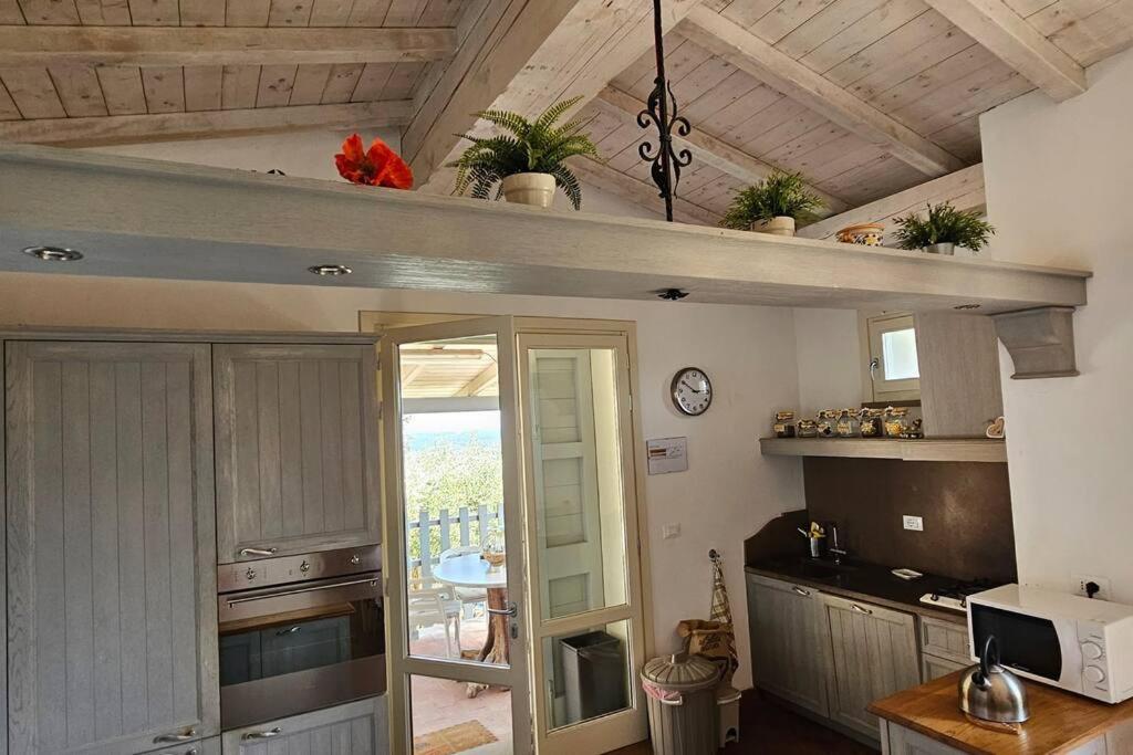 une cuisine avec vue sur un balcon avec une horloge dans l'établissement Podere San Martino, à Buti