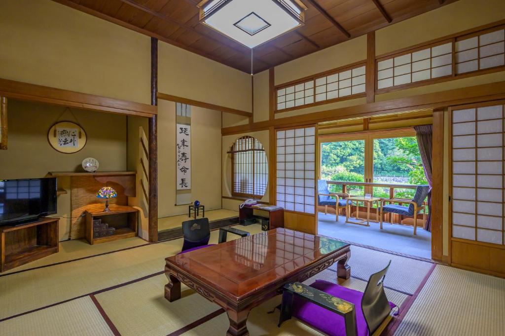 un salon avec une table et des chaises en bois dans l'établissement Ryokan Ohashi, à Misasa