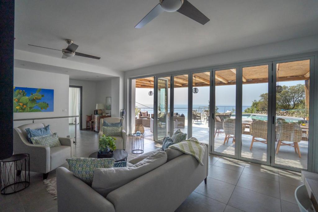 - un salon avec un canapé et une vue sur l'océan dans l'établissement Villa Donna Cà con vista mare e piscina privata, à Coccorino