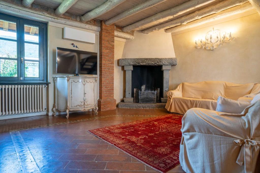 un salon avec une cheminée et un canapé dans l'établissement Villa Mia con SPA e piscina, à Corte Franca