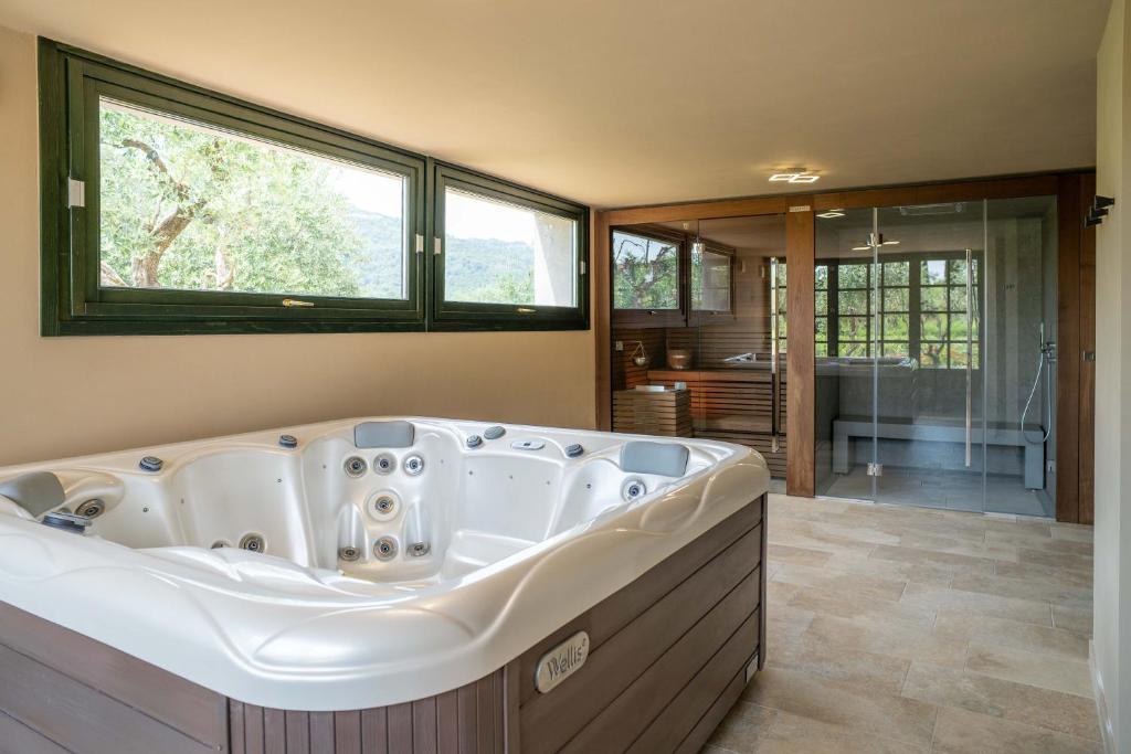 une grande baignoire dans une salle de bain avec une fenêtre dans l'établissement Villa Mia con SPA e piscina, à Corte Franca