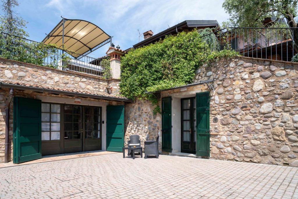 - un bâtiment en pierre avec une chaise devant dans l'établissement Villa Mia con SPA e piscina, à Corte Franca