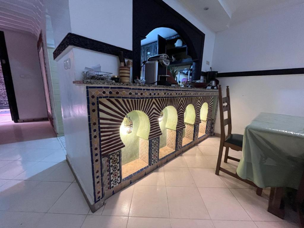 une salle à manger avec une table et un mur avec un four dans l'établissement Riad Benhammou1, à Marrakech