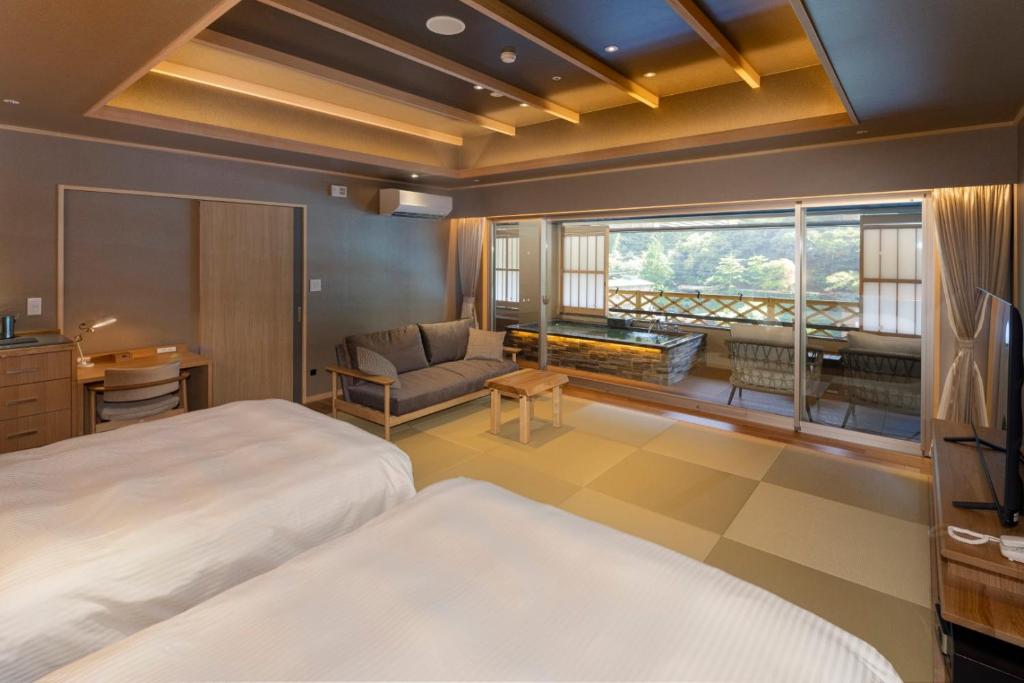 une chambre avec un lit et un salon dans l'établissement Hotel Okada, à Hakone