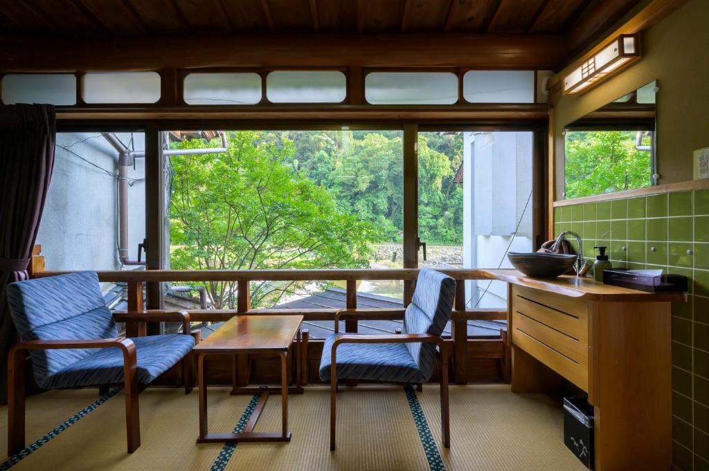 une cuisine avec une table et des chaises et une fenêtre dans l'établissement Ryokan Ohashi, à Misasa