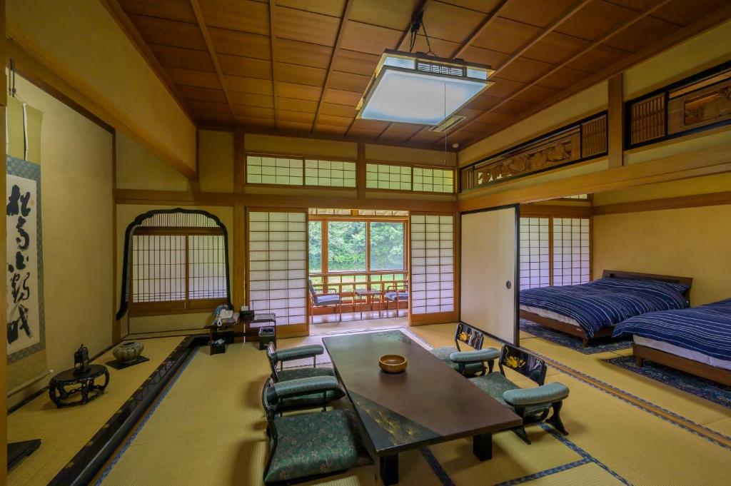 une chambre avec un lit, une table et des chaises dans l'établissement Ryokan Ohashi, à Misasa 37 autres photos