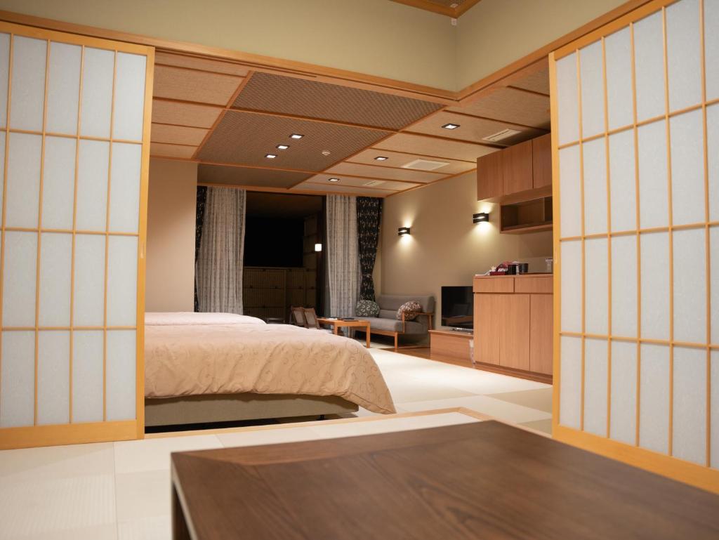une chambre avec un lit et un salon dans l'établissement Manten no Yado, à Gujō