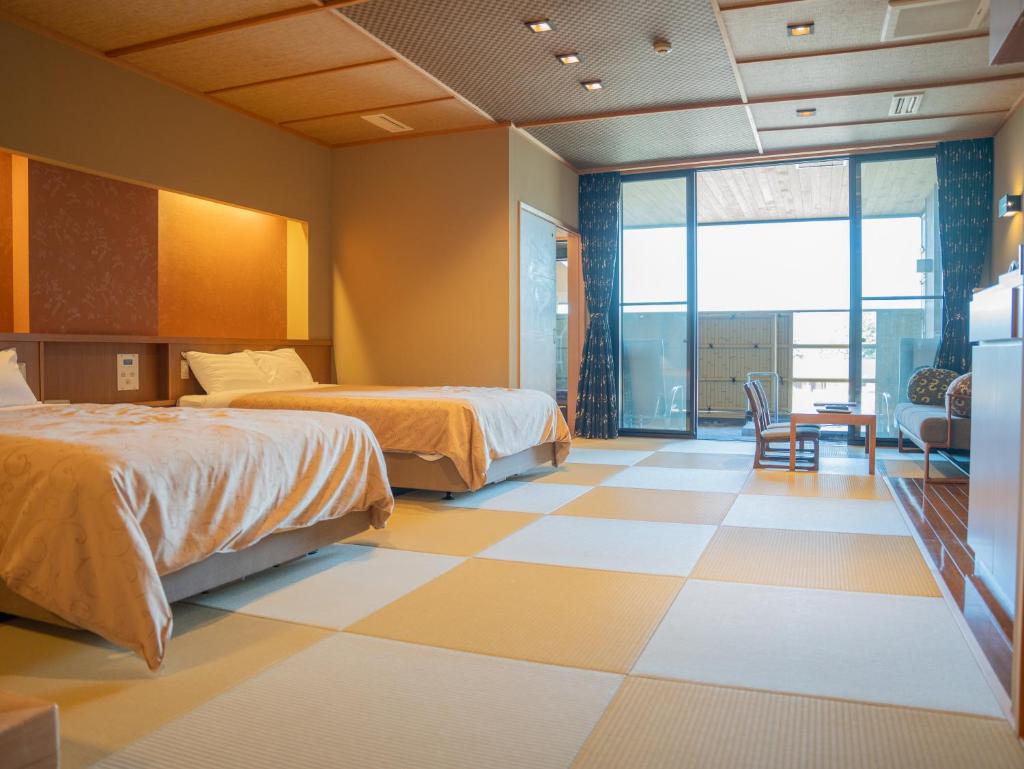 Cette chambre dispose de deux lits et de carrelage. dans l'établissement Manten no Yado, à Gujō
