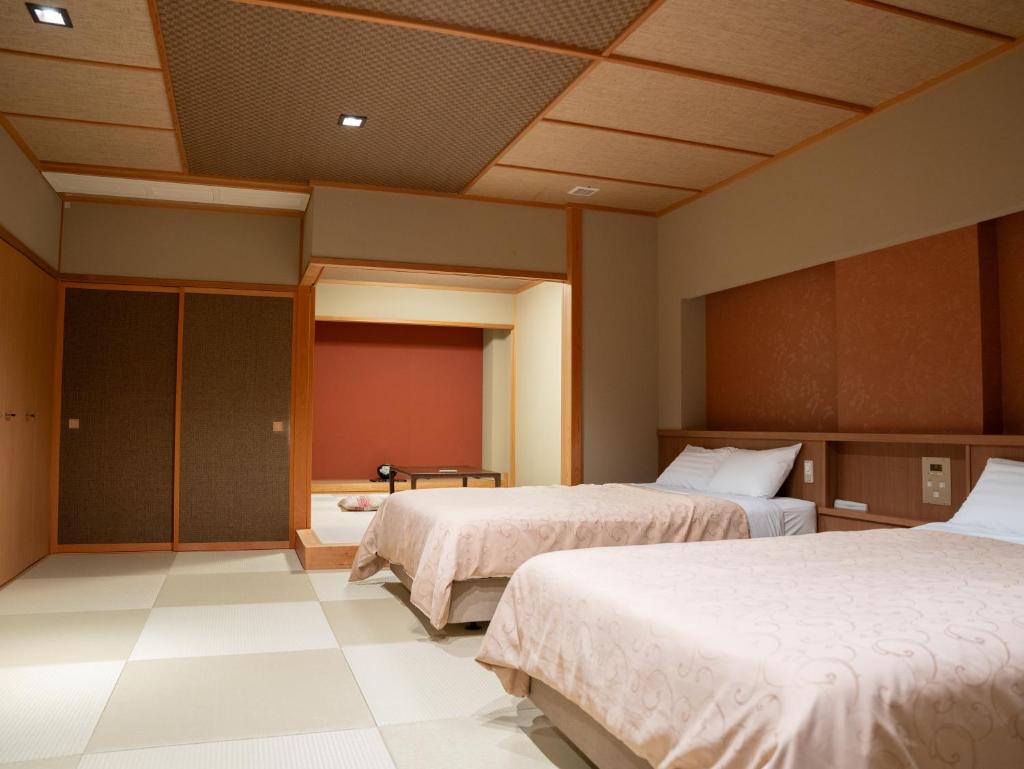 une chambre d'hôtel avec deux lits et une chambre avec dans l'établissement Manten no Yado, à Gujō