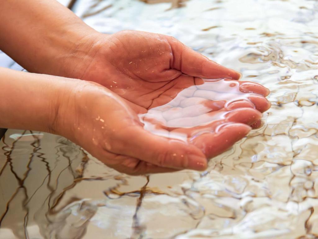 une personne tient un tas de sable dans les mains dans l'établissement Suzuranso, à Komagane
