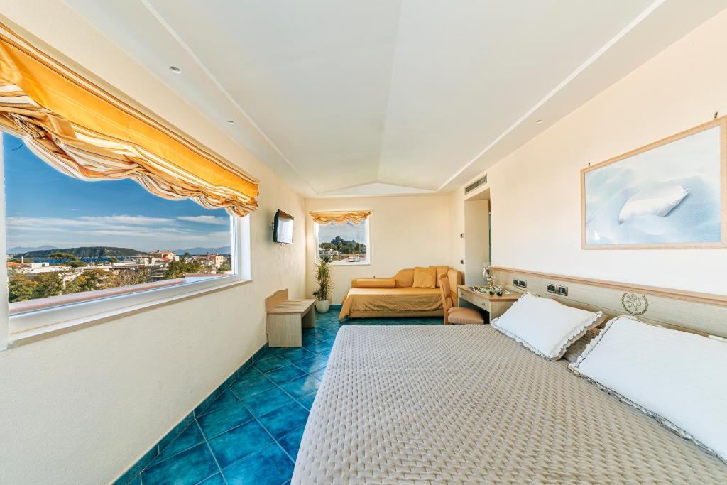 Cette chambre comprend un lit et une grande fenêtre. dans l'établissement Hotel Regina Palace Terme, à Ischia 29 autres photos