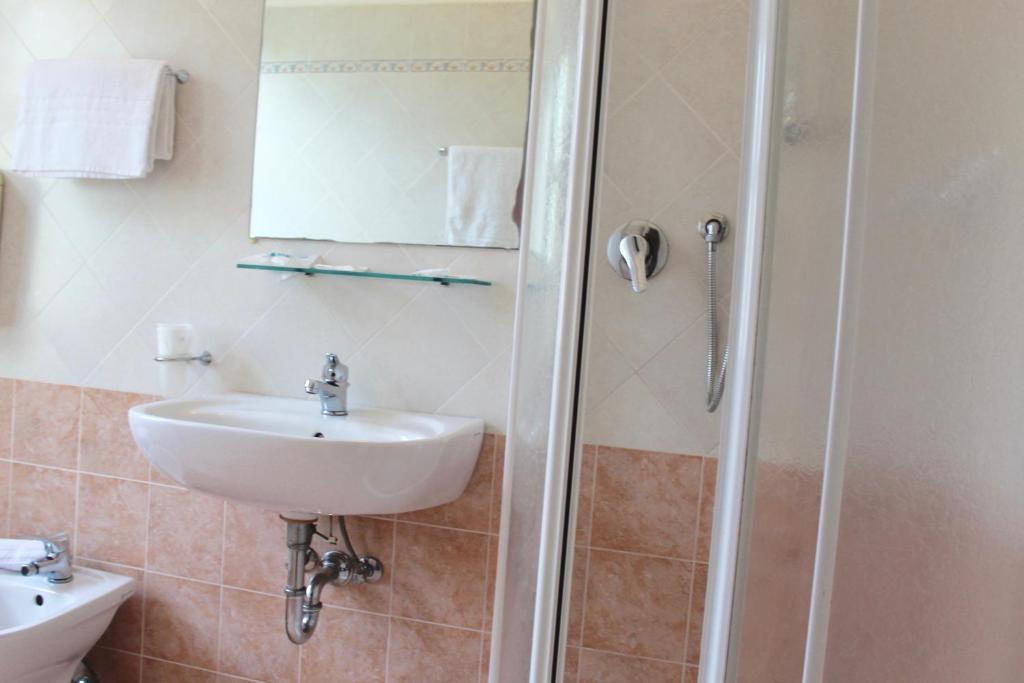une salle de bain avec un lavabo et une douche dans l'établissement Roi Hotel, à Cesenatico