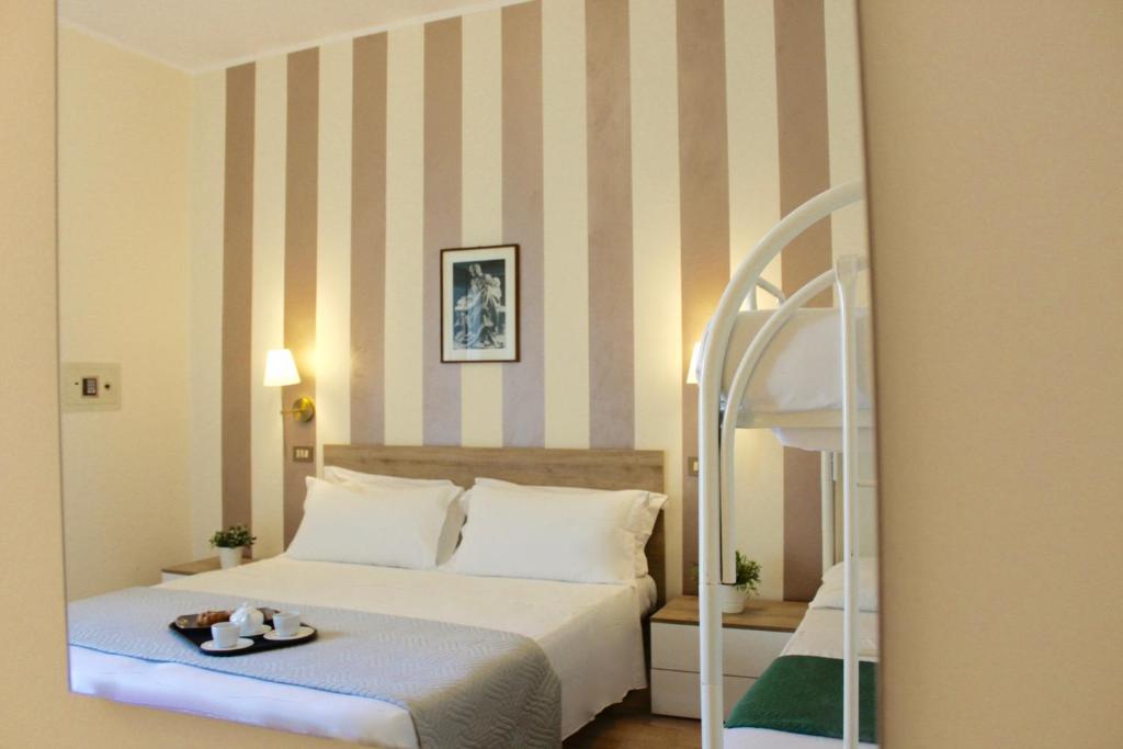 une chambre d'hôtel avec un lit et un miroir dans l'établissement Roi Hotel, à Cesenatico