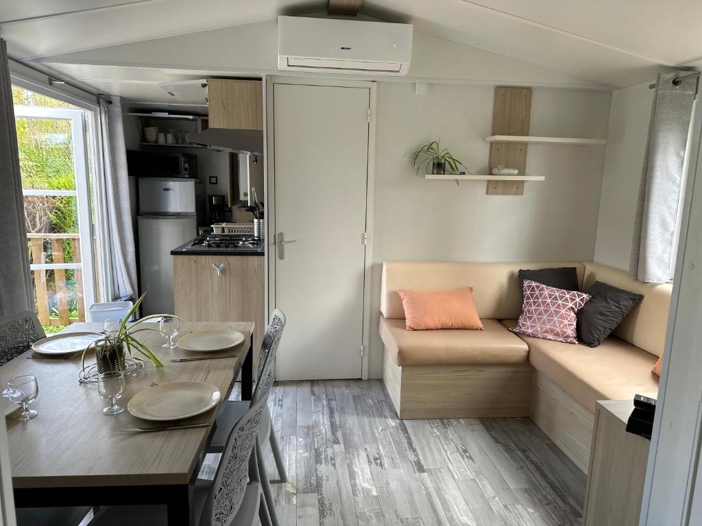 un petit salon avec une table et un canapé dans l'établissement Mobil home XL confort, à Ivry-la-Bataille