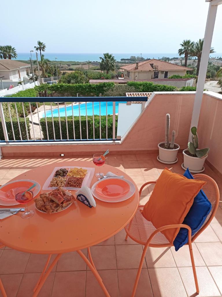 une table avec une assiette de nourriture sur un balcon dans l'établissement Tedimo Mare, à Marina di Ragusa 82 autres photos