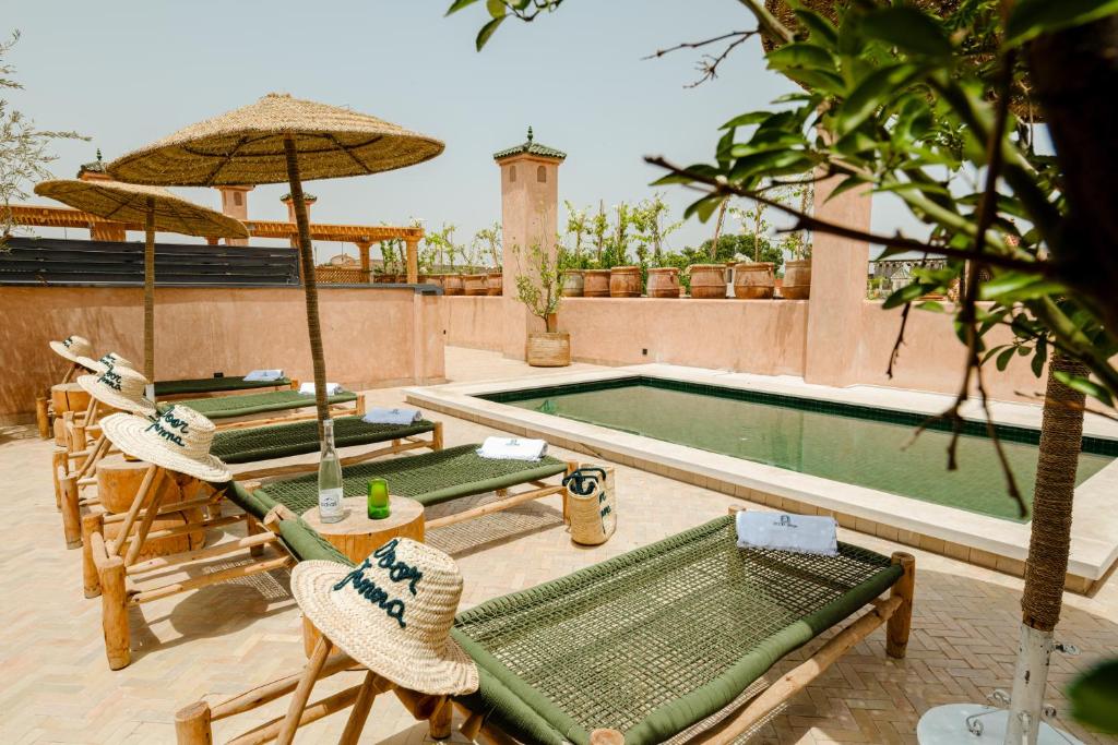 - une piscine avec des chaises et des parasols à côté dans l'établissement Door Janna, à Marrakech