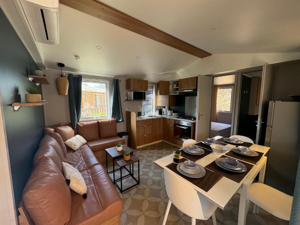 un salon avec un canapé et une table dans l'établissement Mobile home 255 pour 6 pers Camping Siblu Le Lac des Rêves, à Lattes