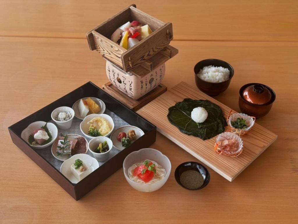 une table remplie de deux boîtes de nourriture et de sushis dans l'établissement Sunrise Katsuura, à Nachikatsuura