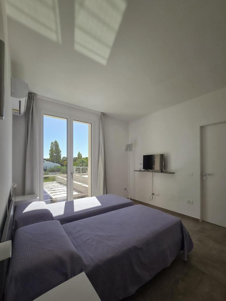 une chambre avec deux lits et une grande fenêtre dans l'établissement Villa Vannì, à Menfi