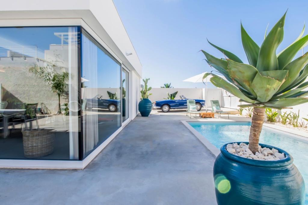 une plante en pot dans un grand pot bleu à côté d'une maison dans l'établissement SIMANA Mediterranean Pool Villas, à Marina di Ragusa
