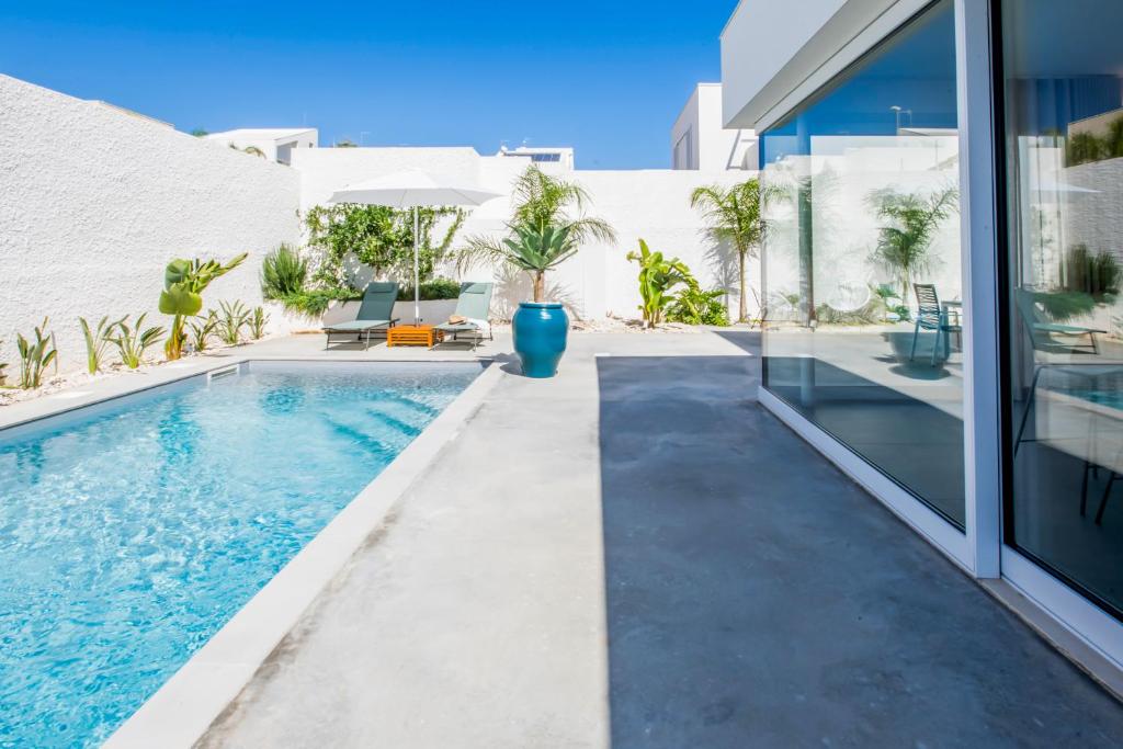 une piscine dans l'arrière-cour d'une maison dans l'établissement SIMANA Mediterranean Pool Villas, à Marina di Ragusa