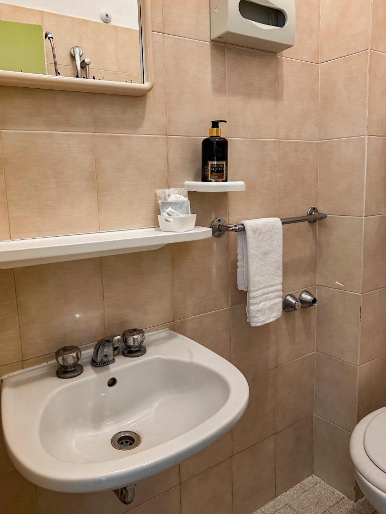 une salle de bain avec un lavabo et des toilettes dans l'établissement Hotel Re Leone, à Rimini