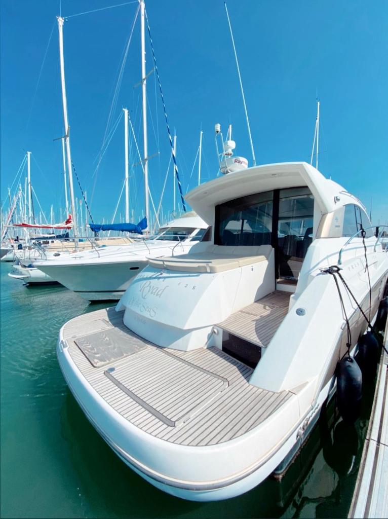 un bateau blanc amarré à un quai avec d'autres bateaux dans l'établissement BOAT PARADISE LA ROCHELLE - Prestige 42S, à La Rochelle