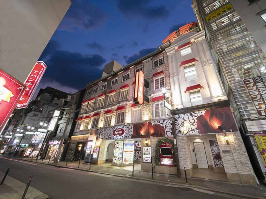 un bâtiment au bord d'une rue la nuit dans l'établissement Rose Lips Shinsaibashi ローズリップス心斎橋アダルトオンリー, à Osaka