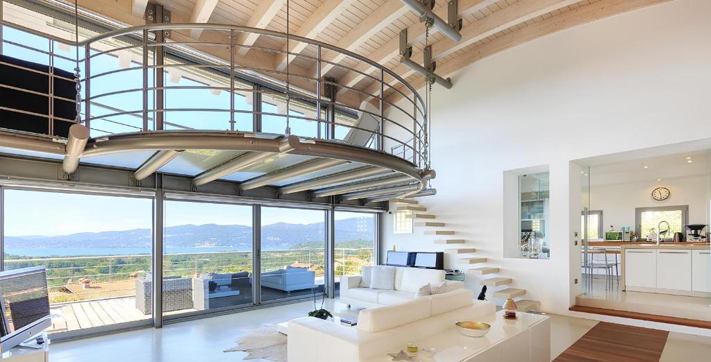 un salon avec un escalier et une grande fenêtre dans l'établissement Villa Panoramica Cardana, à Besozzo