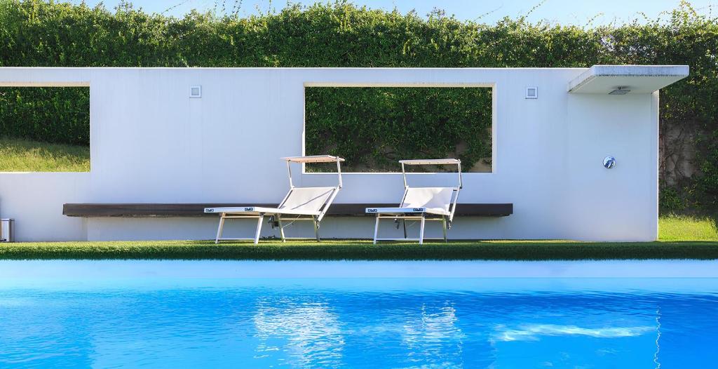 deux chaises et une table à côté d'une piscine dans l'établissement Villa Panoramica Cardana, à Besozzo