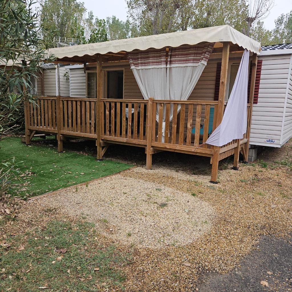 une maison avec une terrasse et un parasol dans l'établissement mobilhome, à Valras-Plage
