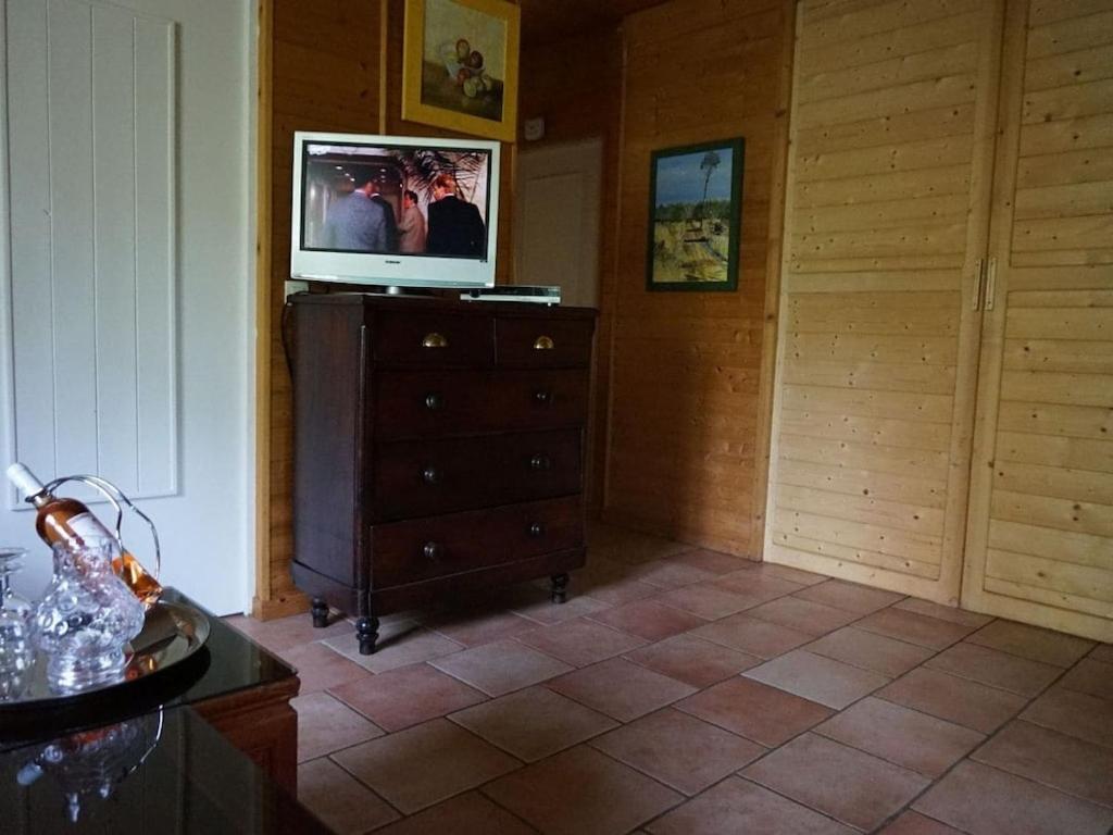 - un salon avec une télévision au-dessus d'une commode dans l'établissement Villa Mimosa Comfortable holiday residence, à Lacanau