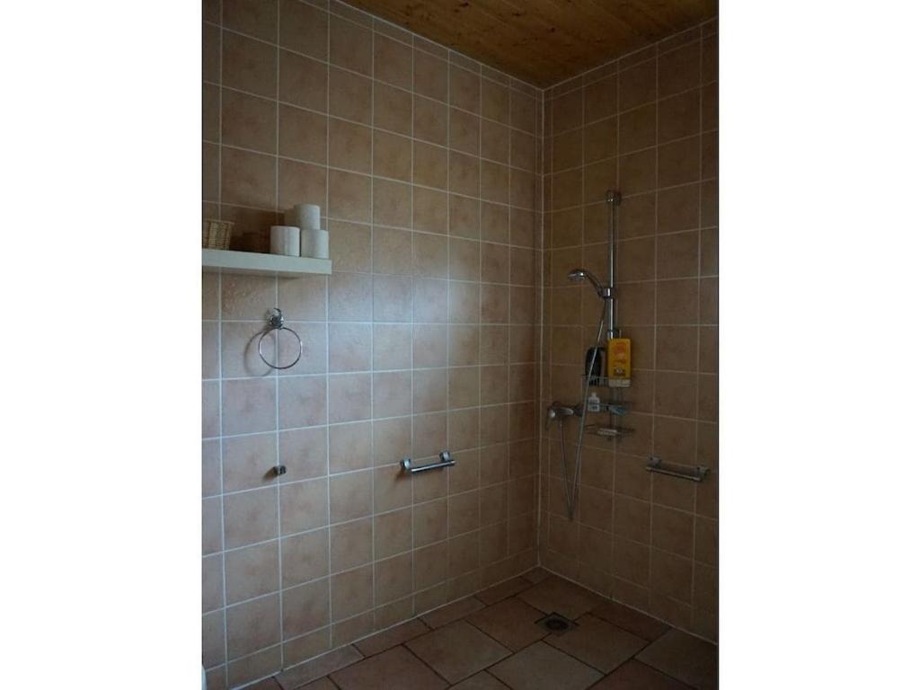 une salle de bain avec douche aux murs carrelés dans l'établissement Villa Mimosa Comfortable holiday residence, à Lacanau