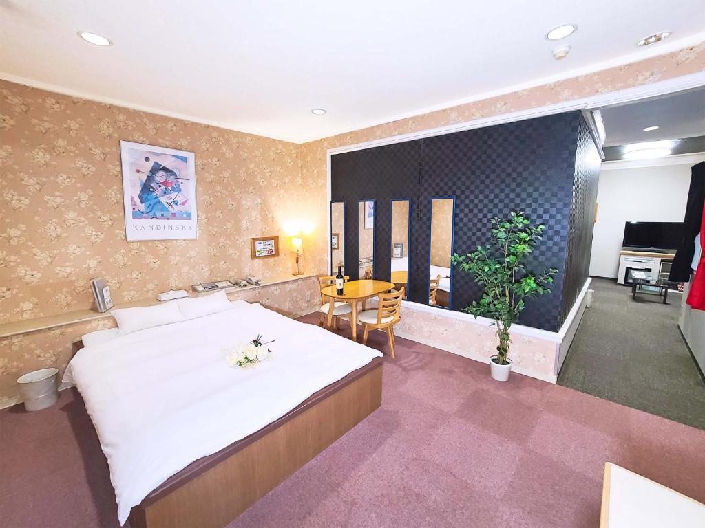 une chambre avec un grand lit et une table dans l'établissement Hotel Annex MIE, à Bungoono