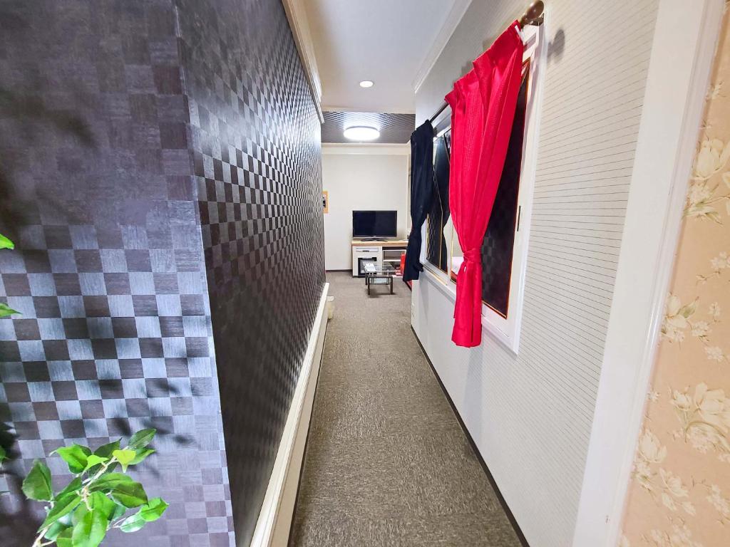 un couloir de salle de bains avec un rideau rouge dans l'établissement Hotel Annex MIE, à Bungoono 8 autres photos