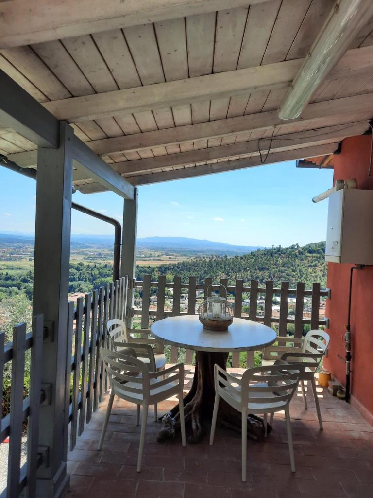 une table et des chaises sur un balcon avec vue dans l'établissement Podere San Martino, à Buti