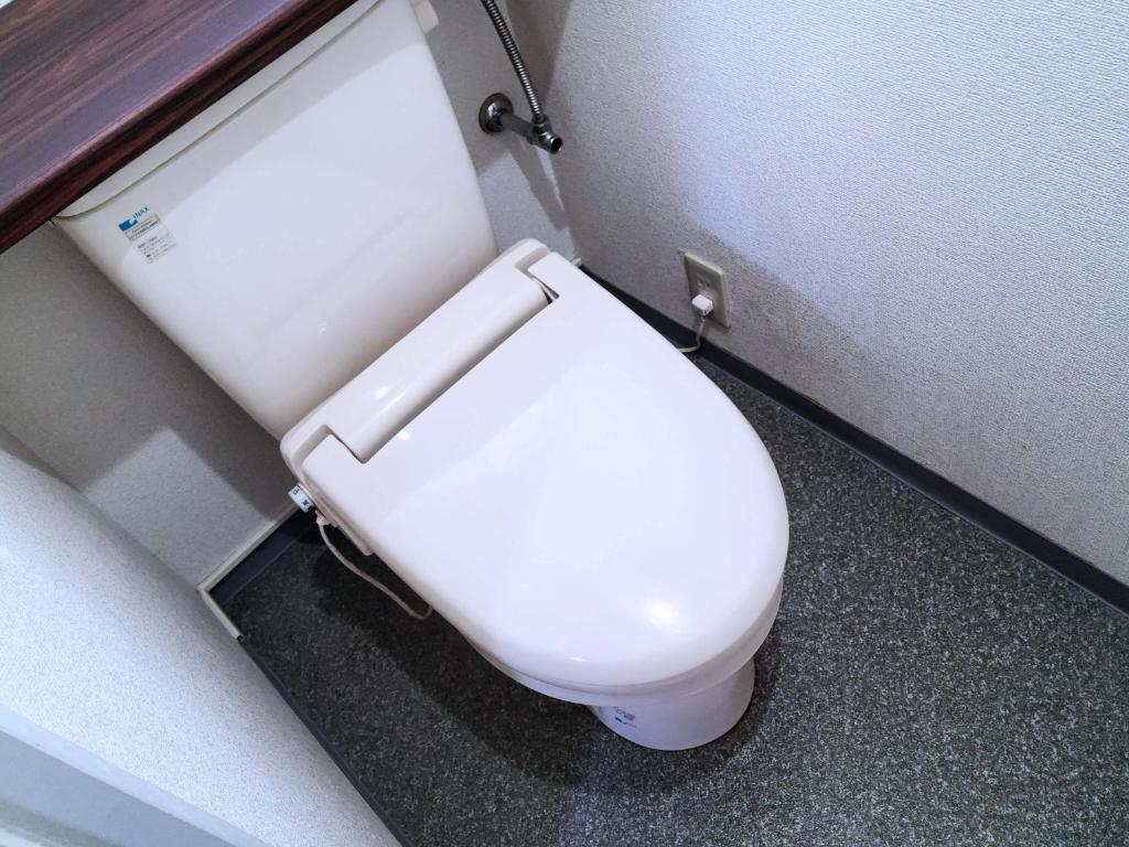 - une salle de bains avec des toilettes blanches dans une cabine dans l'établissement Hotel Annex NOTSU, à Usuki
